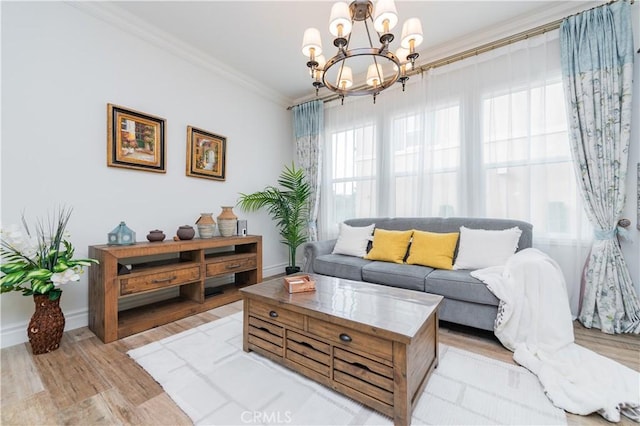 living room with crown molding, a chandelier, and light hardwood / wood-style floors