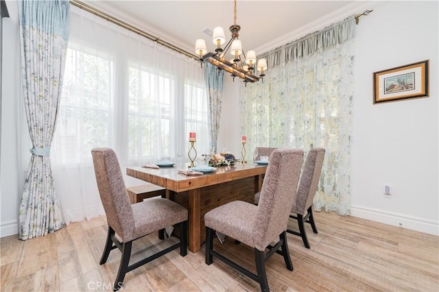 dining room featuring light hardwood / wood-style flooring, ornamental molding, and a chandelier