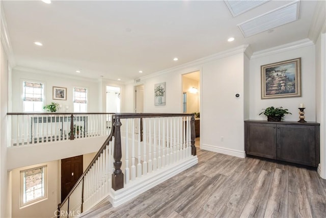 corridor with light wood-type flooring, a skylight, and crown molding