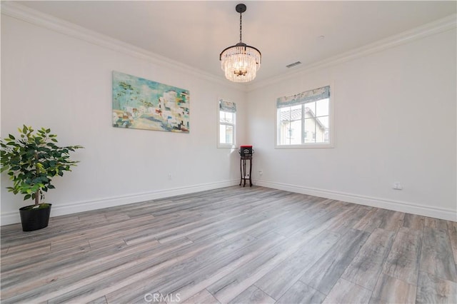 unfurnished room featuring light hardwood / wood-style flooring, ornamental molding, and a chandelier