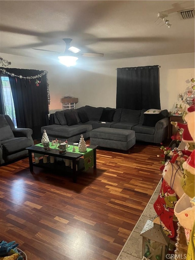 living room featuring ceiling fan and dark hardwood / wood-style floors