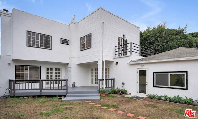 back of house with a wooden deck, french doors, and a yard