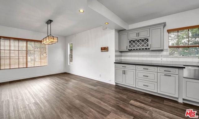 kitchen featuring backsplash, dark hardwood / wood-style flooring, and a wealth of natural light