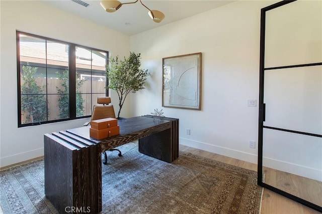 office space with hardwood / wood-style flooring and a notable chandelier