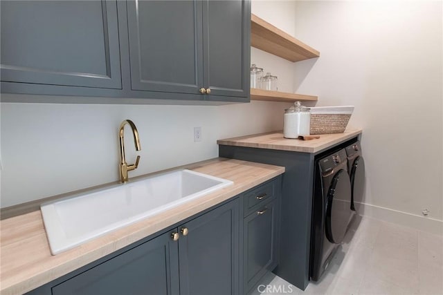 washroom featuring light tile patterned floors, cabinets, washer and dryer, and sink