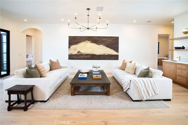 living room with light hardwood / wood-style floors and a chandelier