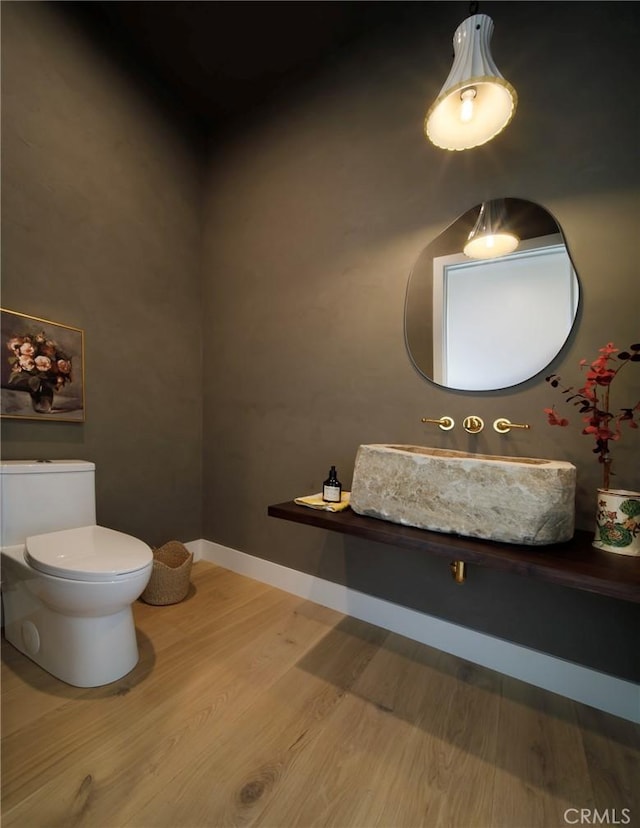 bathroom featuring sink, wood-type flooring, and toilet