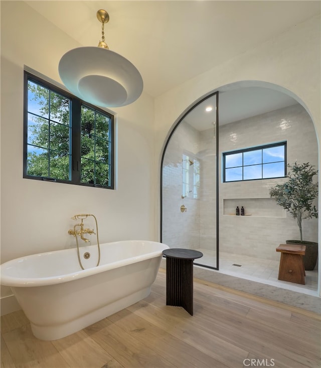 bathroom with hardwood / wood-style floors and shower with separate bathtub