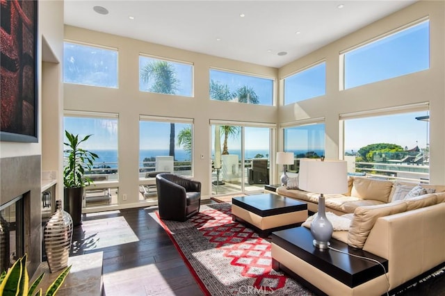 sunroom featuring a fireplace and a water view