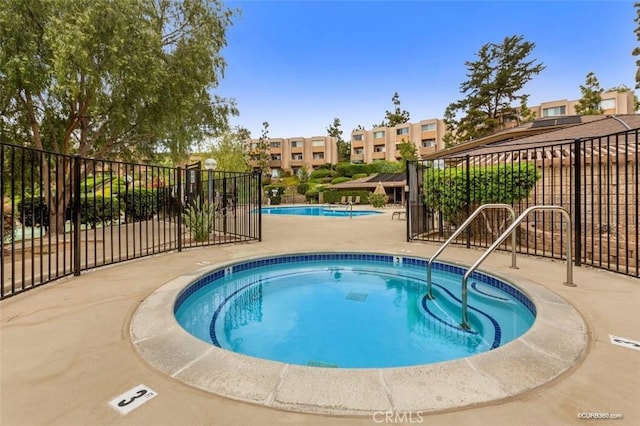 view of swimming pool with a patio and a hot tub