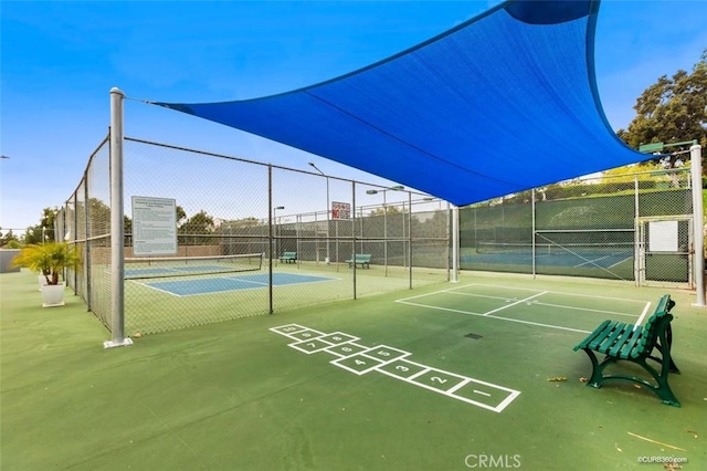 view of property's community featuring tennis court