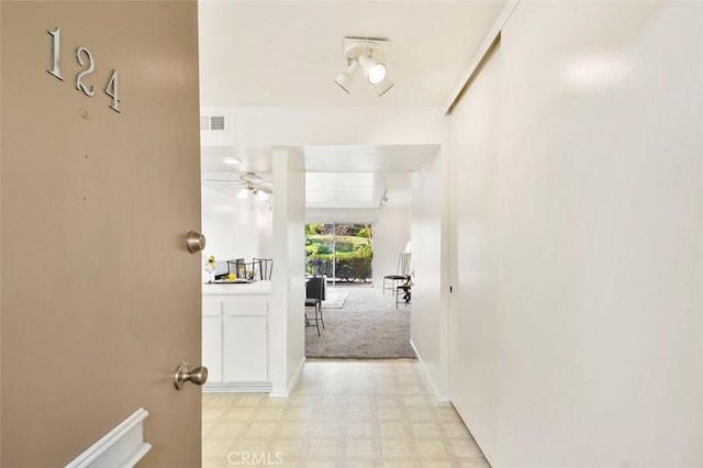 hallway featuring light carpet