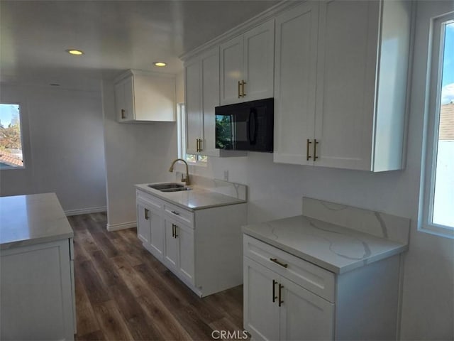 kitchen with dark wood-type flooring, sink, light stone counters, and white cabinets