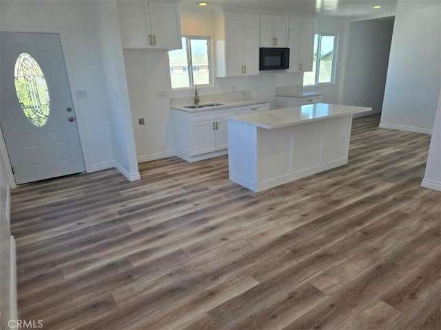 kitchen with white cabinets, dark hardwood / wood-style flooring, sink, and a kitchen island