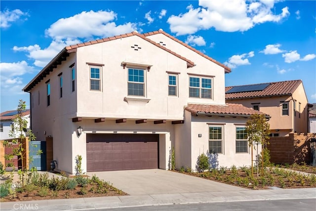 mediterranean / spanish home featuring a garage, fence, driveway, and stucco siding