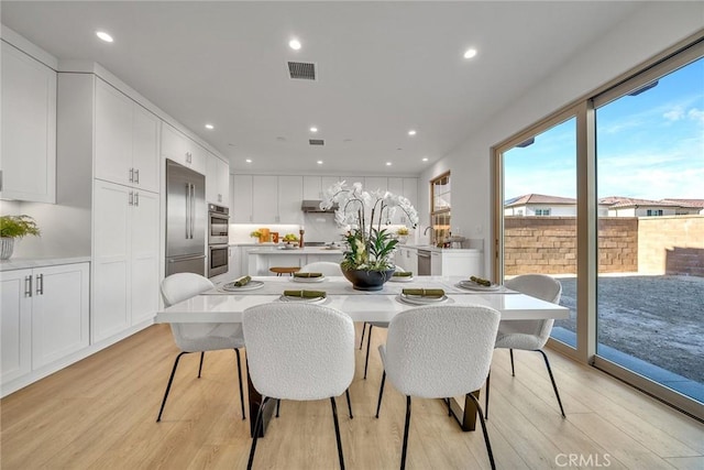 dining room with light wood-style floors, visible vents, and recessed lighting