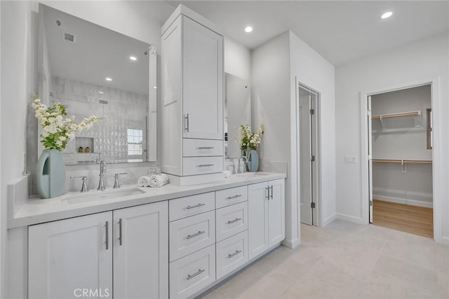 full bathroom featuring a stall shower, a sink, recessed lighting, and double vanity