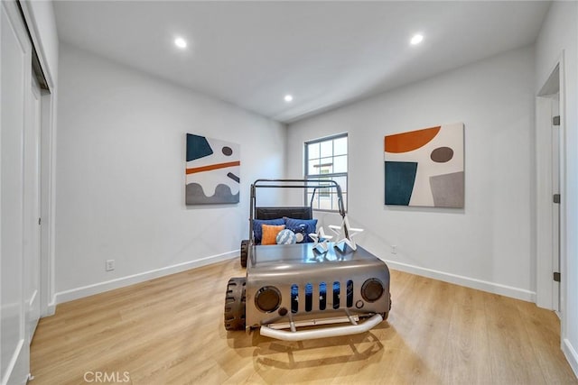 bedroom with recessed lighting, wood finished floors, and baseboards