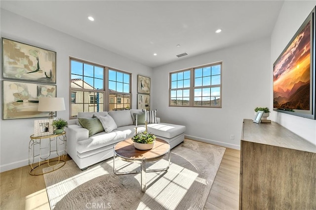 living room featuring light wood-style floors, visible vents, baseboards, and recessed lighting