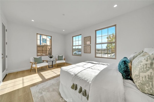 bedroom with multiple windows, baseboards, wood finished floors, and recessed lighting