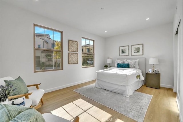 bedroom featuring light wood finished floors, baseboards, and recessed lighting