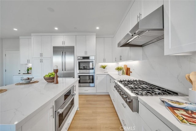 kitchen with under cabinet range hood, white cabinetry, and stainless steel appliances