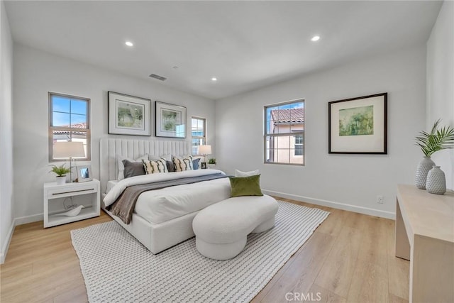 bedroom featuring light wood finished floors, baseboards, and visible vents