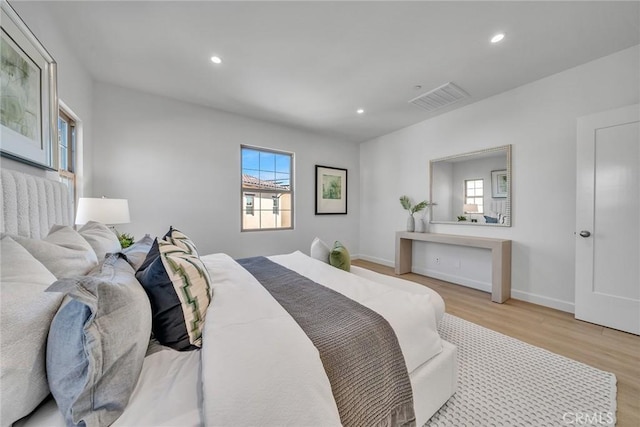 bedroom featuring baseboards, visible vents, wood finished floors, and recessed lighting