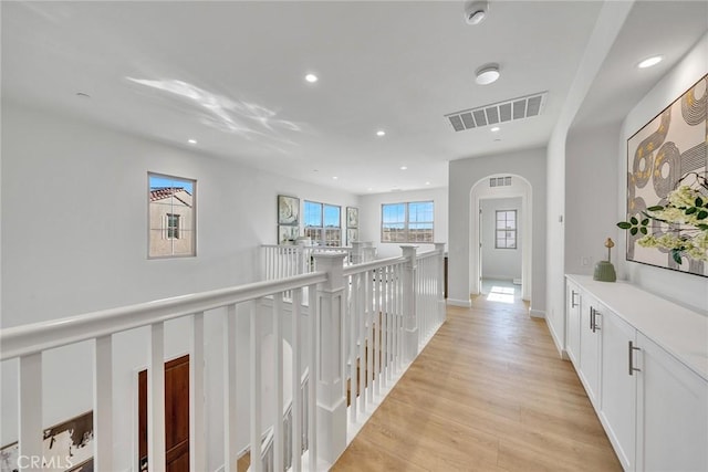 corridor featuring light wood-style flooring, an upstairs landing, visible vents, and recessed lighting