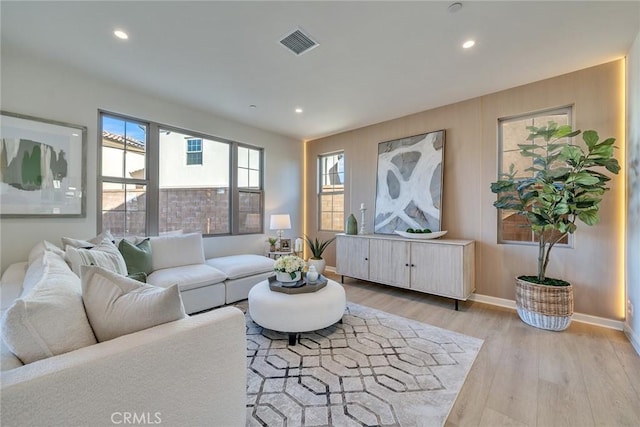 living area with light wood-type flooring, baseboards, visible vents, and recessed lighting