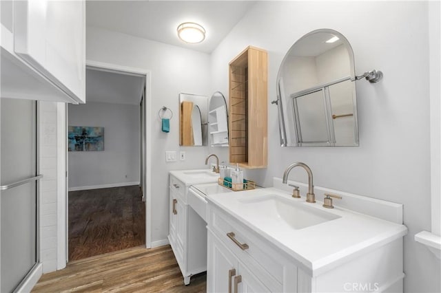 bathroom with walk in shower, vanity, and wood-type flooring