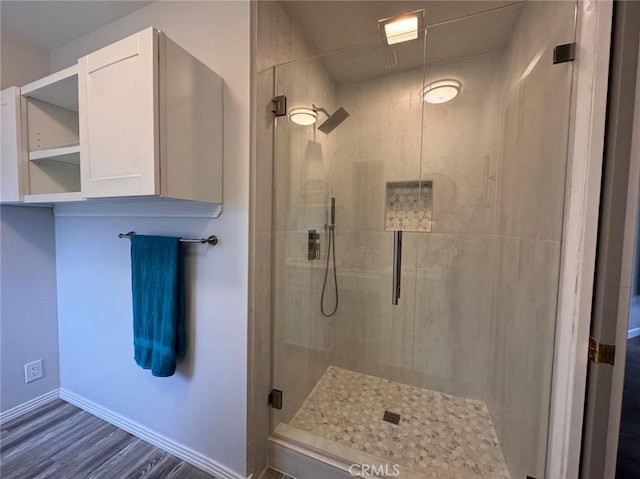 bathroom featuring a shower with shower door and hardwood / wood-style floors