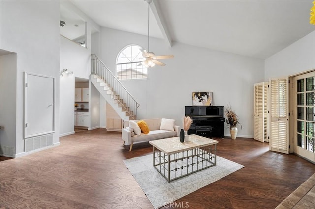 living room featuring dark wood-type flooring, ceiling fan, beam ceiling, and high vaulted ceiling