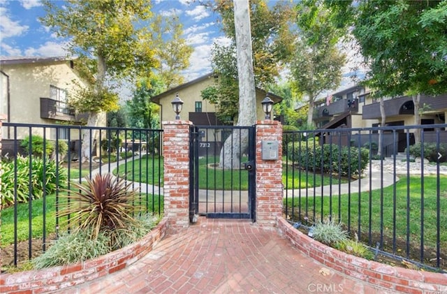 view of gate with a lawn