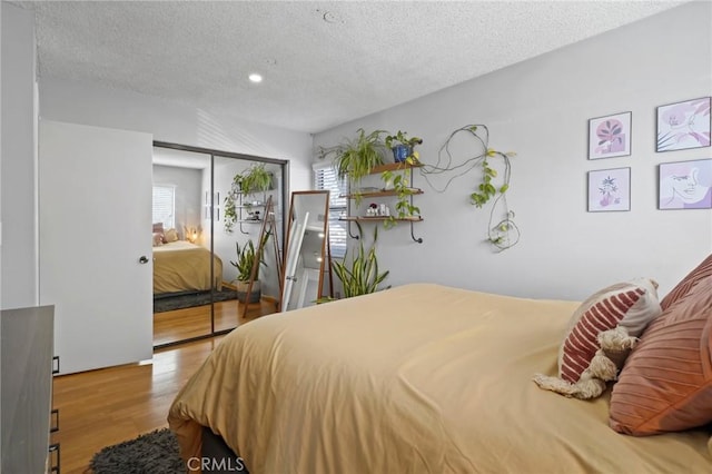 bedroom featuring a textured ceiling, hardwood / wood-style flooring, and a closet