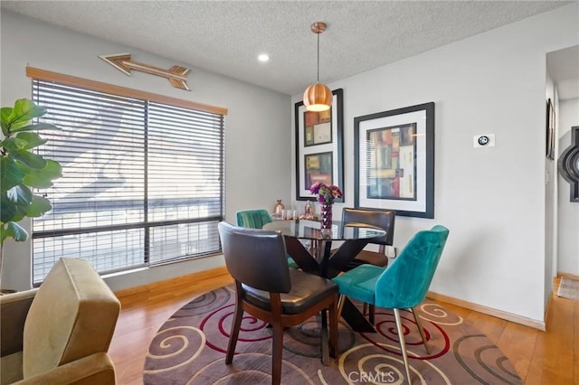 dining room with a wealth of natural light, a textured ceiling, and hardwood / wood-style flooring