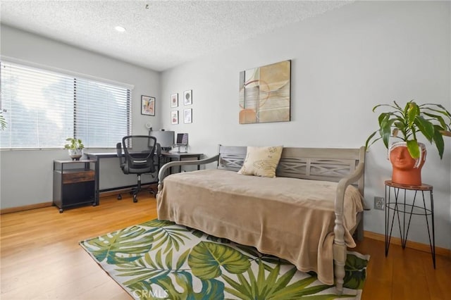 bedroom featuring hardwood / wood-style floors and a textured ceiling