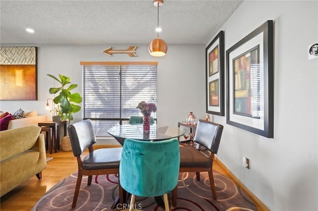 dining room with plenty of natural light, hardwood / wood-style floors, and a textured ceiling