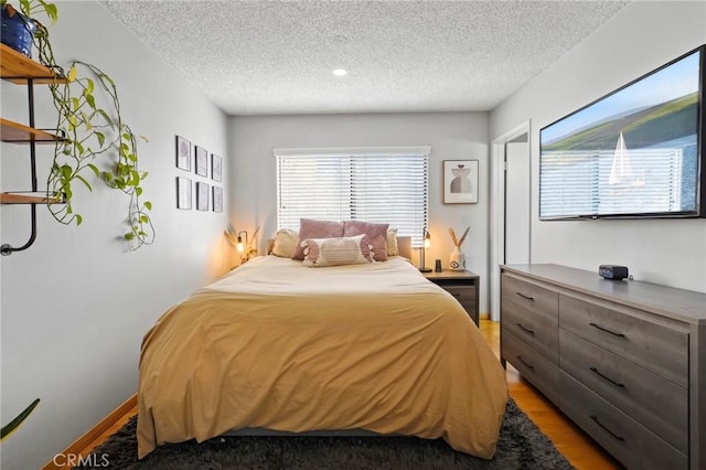 bedroom featuring a textured ceiling and hardwood / wood-style flooring