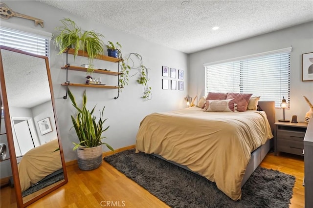 bedroom featuring a textured ceiling and hardwood / wood-style flooring