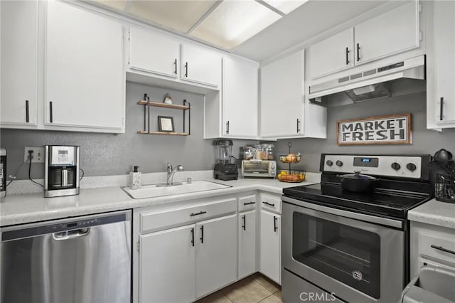 kitchen featuring sink, white cabinets, light tile patterned floors, and appliances with stainless steel finishes