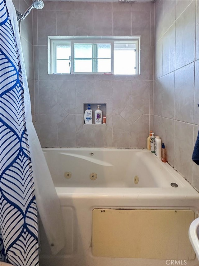 bathroom with a healthy amount of sunlight and shower / bath combo with shower curtain