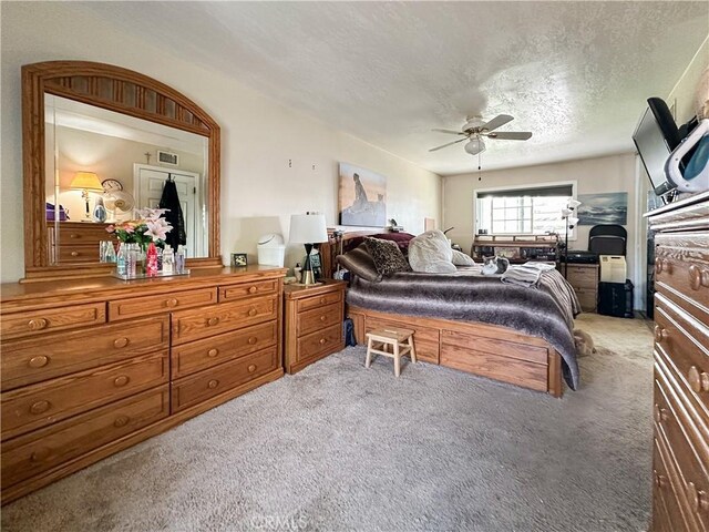 carpeted bedroom featuring a textured ceiling and ceiling fan