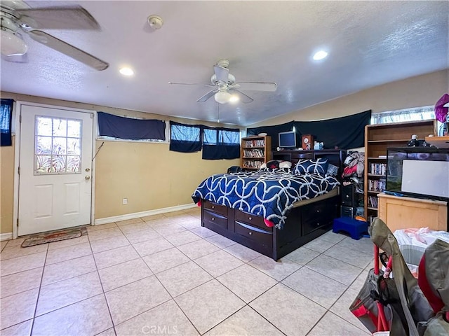 bedroom with light tile patterned flooring, ceiling fan, and a textured ceiling