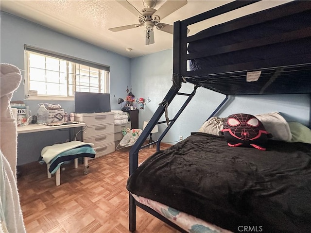 bedroom with light parquet floors, a textured ceiling, and ceiling fan