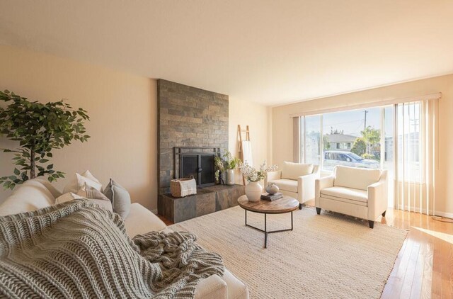 living room with a tiled fireplace and hardwood / wood-style floors