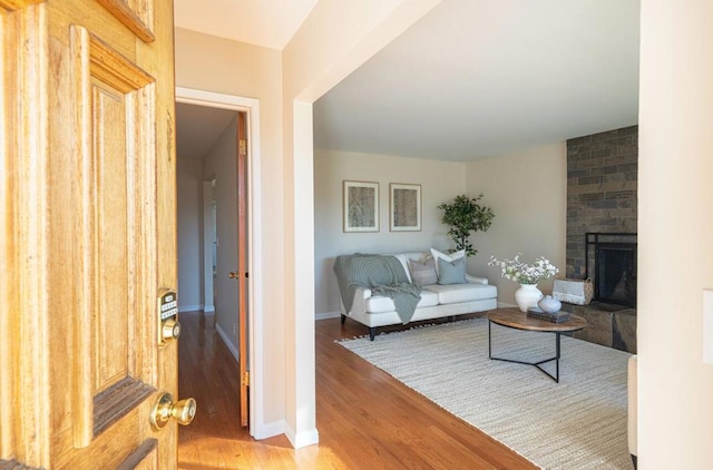 living room featuring a brick fireplace and hardwood / wood-style floors