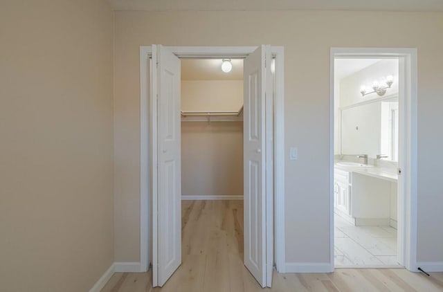 corridor featuring sink and light hardwood / wood-style floors