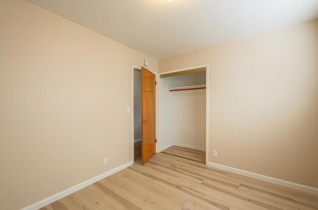 unfurnished bedroom featuring a closet and light hardwood / wood-style floors