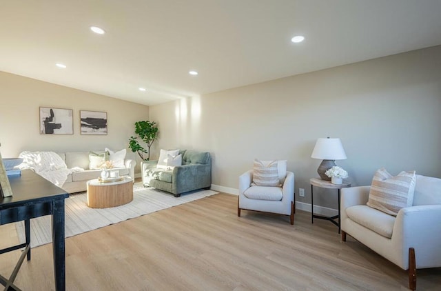 living room with lofted ceiling and light hardwood / wood-style flooring